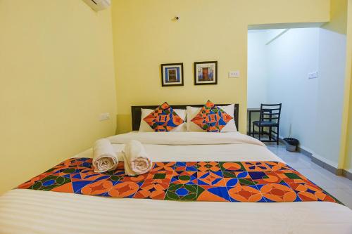 a bedroom with a large bed with towels on it at FabExpress Symphony Homes, Calangute Beach in Old Goa