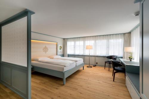 a hotel room with a bed and a desk and a desk at Hotel Krone Speicher in Speicher