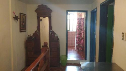 a living room with a grandfather clock and a hallway at CASA JUANITA in San Miguel de Allende