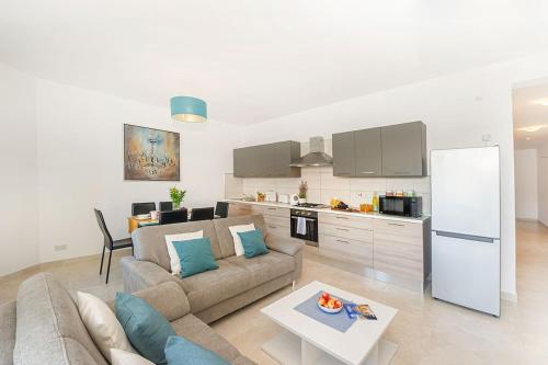 a living room with a couch and a kitchen at Hillock Residence Apartments in Marsalforn