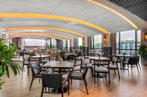 un ristorante con tavoli e sedie in una stanza con finestre di The Outpost Hotel Sentosa by Far East Hospitality a Singapore