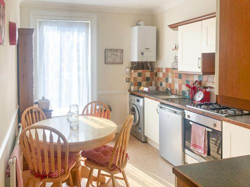 uma cozinha com uma mesa e cadeiras numa cozinha em Coastal Hideaway em Sandown