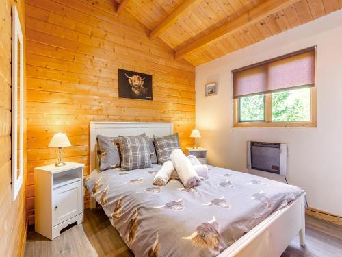 a bedroom with a bed in a wooden cabin at The Willows in Glencoe