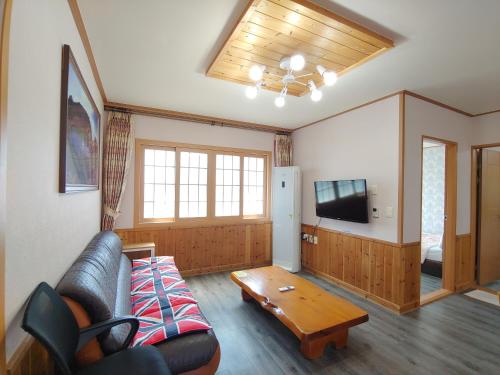 a living room with a couch and a coffee table at Gyulhouse Pension in Seogwipo