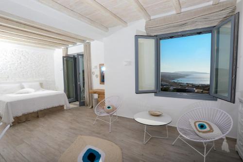 a bedroom with a bed and a large window at Villa Elia by Mykonian Kazarte in Kalafatis