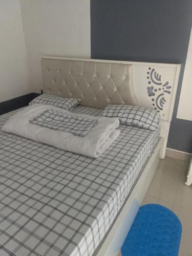 a bed with a gray and white mattress and a blue rug at Ignite guest and apartment in Rubavu