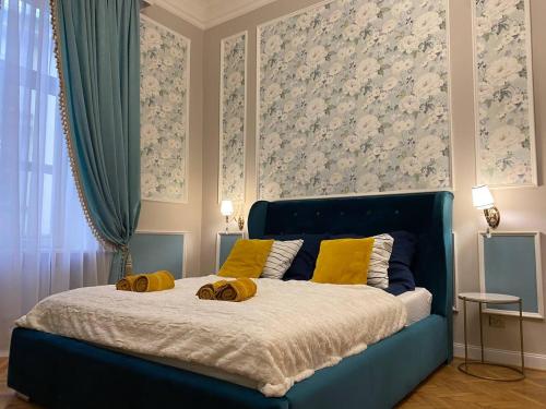 Un dormitorio con una cama azul con almohadas amarillas. en Radiance Residence, en Cracovia