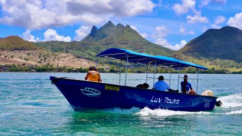 un grupo de personas en un barco azul en el agua en LUV TOURS, en Centre de Flacq