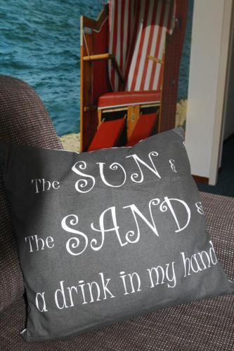 a pillow that says the sun is a drink in my hand at 't STRANDHUYS en DE VUURTOREN, met eigen KEUKEN, ZONNIG TERRAS nabij DORP, DUINEN en STRAND, Incl verwarmd binnen ZWEMBAD in Hollum
