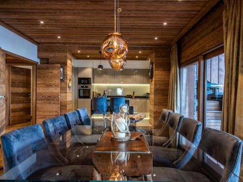 une salle à manger avec une table et des chaises bleues dans l'établissement Appartement de Luxe avec Cheminée, Jacuzzi et Hammam, Skis aux Pieds - Méribel - FR-1-613-84, à Les Allues