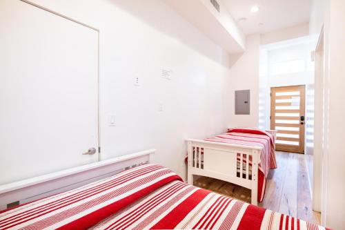 two beds in a white room with red and white stripes at New York loft- style 3 levels 2 Bath by Hollywood in Los Angeles