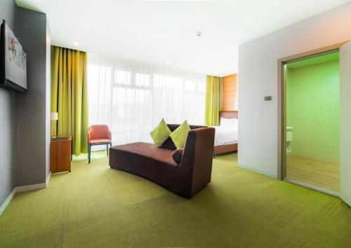 International Hotel in Ulaanbaatar في أولان باتور: غرفة في الفندق مع أريكة وسرير