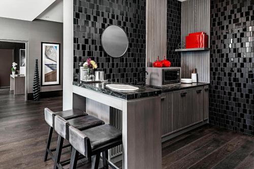 a kitchen with a counter with a sink and a mirror at Toronto Marriott Markham in Markham