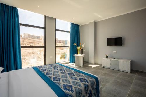sypialnia z łóżkiem i dużym oknem w obiekcie Shellghada Blue Beach w mieście Hurghada
