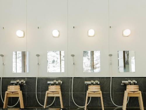 a row of sinks in a bathroom with mirrors at Ryokan Kigusuriya in Nantan city