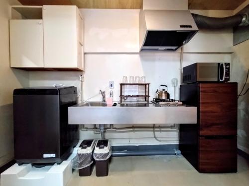a small kitchen with a sink and a stove at 酒と宿と不動産-yado- in Yokosuka