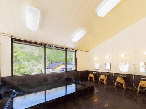a large room with a large window and an aquarium at Ryokan Kigusuriya in Nantan city