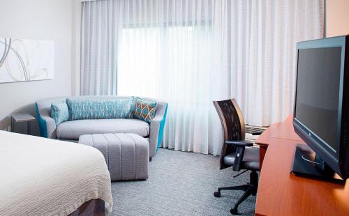ロアノークにあるCourtyard by Marriott Roanoke Airportのベッドとテレビ付きのホテルルーム