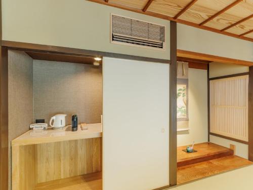 a kitchen with a sliding door in a room at Ryokan Kigusuriya in Nantan city