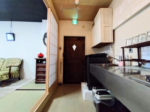 a kitchen with a long counter and a door at 酒と宿と不動産-yado- in Yokosuka