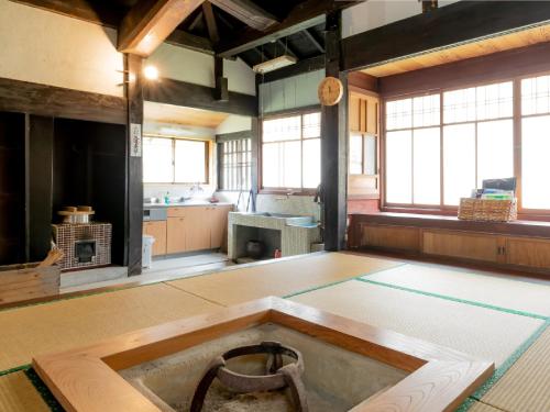 a large room with a kitchen with a wheel on the floor at Ryokan Kigusuriya in Nantan city