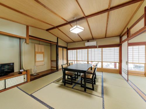 a dining room with a table and chairs at Ryokan Kigusuriya in Nantan city