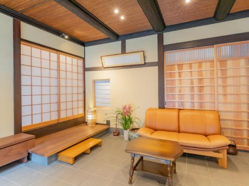 a living room with a couch and a bench at Ryokan Kigusuriya in Nantan city