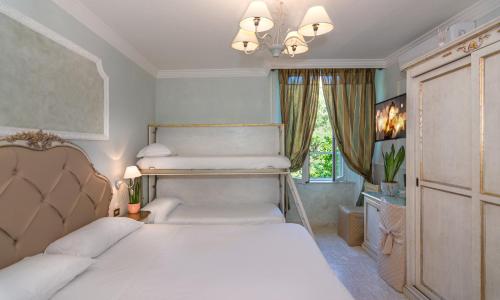 1 dormitorio con 2 camas y lámpara de araña en Hotel Tahiti, en Viareggio