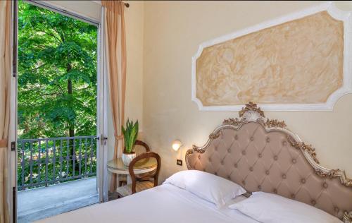 ヴィアレッジョにあるHotel Tahitiのベッドルーム1室(ベッド1台、窓、テーブル付)