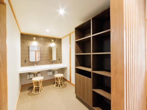 a bathroom with a vanity and a sink and a mirror at Ryokan Kigusuriya in Nantan city