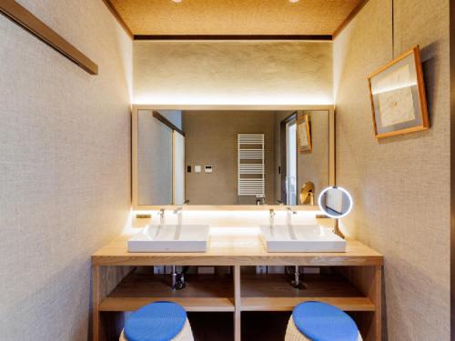 a bathroom with two sinks and a large mirror at Ryokan Kigusuriya in Nantan city