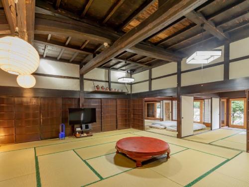 a living room with a table and a tv at Ryokan Kigusuriya in Nantan city