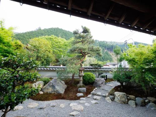 a garden with rocks and trees and a building at Ryokan Kigusuriya in Nantan city
