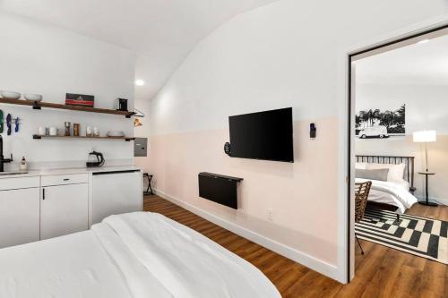 a white bedroom with a bed and a mirror at Waiakapuhi Studio suite.ʻoluʻolu pālua in Chandler