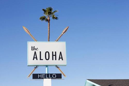 a sign for the aloha hotel with a palm tree at Waiakapuhi Studio suite.ʻoluʻolu pālua in Chandler