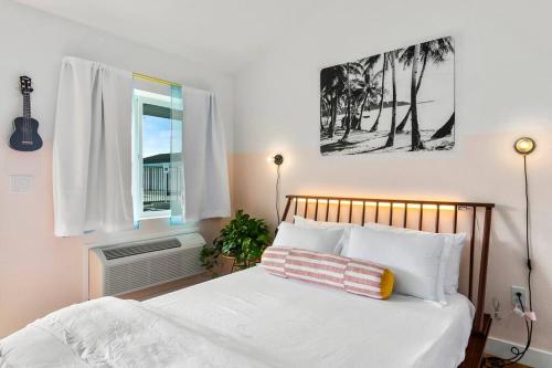 a bedroom with a bed with white sheets and a window at Waiakapuhi Studio suite.ʻoluʻolu pālua in Chandler