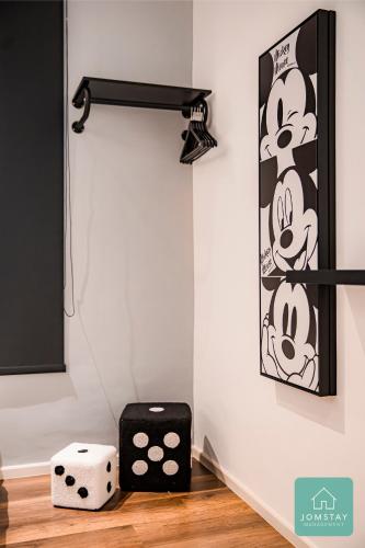 a room with a wall with a mickey mouse poster and dice at JOMSTAY Sunway Onsen Suites Ipoh - Lost World of Tambun Ipoh Waterpark in Tambun