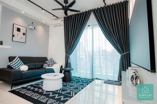 a living room with a couch and a large window at JOMSTAY Sunway Onsen Suites Ipoh - Lost World of Tambun Ipoh Waterpark in Tambun