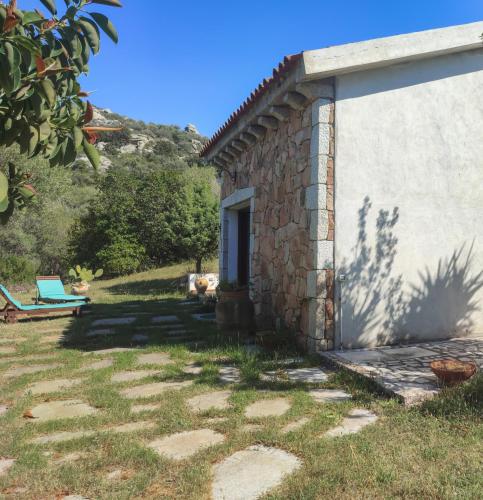 a stone building with a chair next to it at Villa Valfrida in San Teodoro