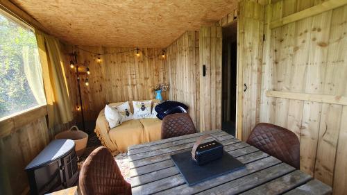 a room with a table and chairs and a bed at Swallow Perch, Willow Hill in Gloucester