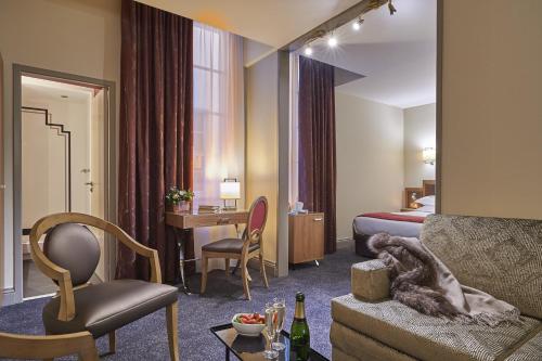 a hotel room with a bed and a living room at Best Western Premier HBEO Bordeaux Centre in Bordeaux