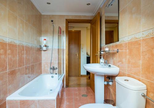ein Badezimmer mit einem WC, einem Waschbecken und einer Badewanne in der Unterkunft Apartamento Irene céntrico con Wifi y parking coche tamaño medio Cangas de Onís in Cangas de Onís