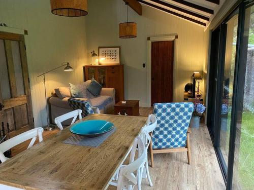 sala de estar con mesa de madera y sillas en Jindabyne - Kia Ora Cabin Farmstay en Moonbah