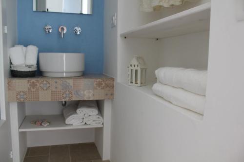 a bathroom with towels on a shelf and a sink at La Casetta 19 in Polignano a Mare