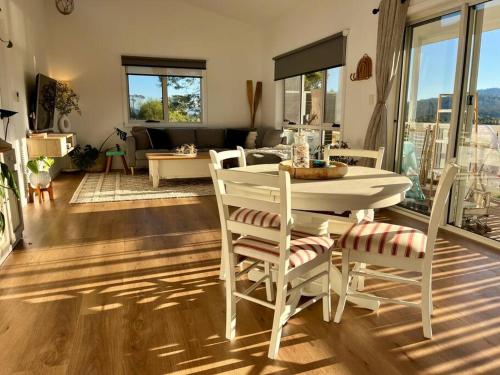 a living room with a white table and chairs at Viola - Seaside Retreat in Coles Bay