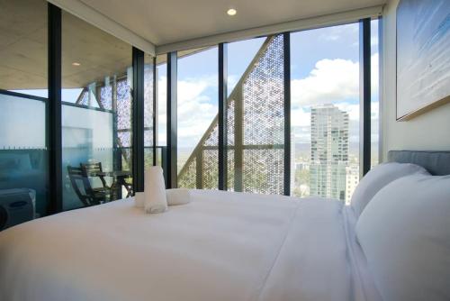 a bedroom with a large white bed and a large window at City Escape at Rundle Mall - Gym - Spa -Steam & Sauna Rooms in Adelaide