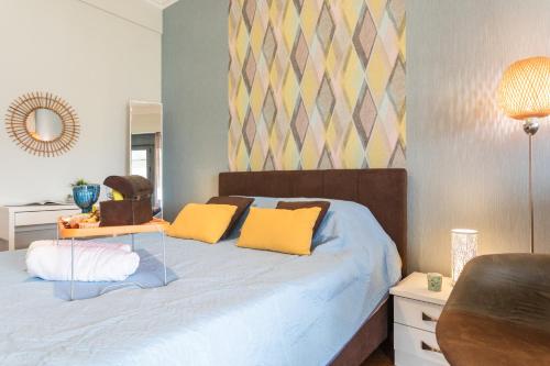 a bedroom with a bed with yellow pillows on it at Beautiful City Rooms close to Acropolis in Athens