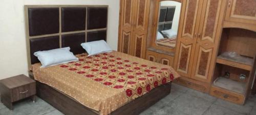 a bedroom with a bed with a dresser and a mirror at SPOT ON 83131 Saini Property in Nārnaul