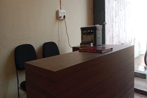 een bureau met een televisie en 2 stoelen in een kamer bij SPOT ON 83131 Saini Property in Nārnaul