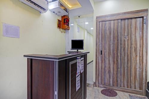 a wooden door in a room with a television at Collection O Hotel Dhruv Tara Inn in Patna